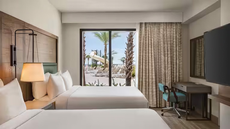 Guest room featuring two queen beds and beach view.